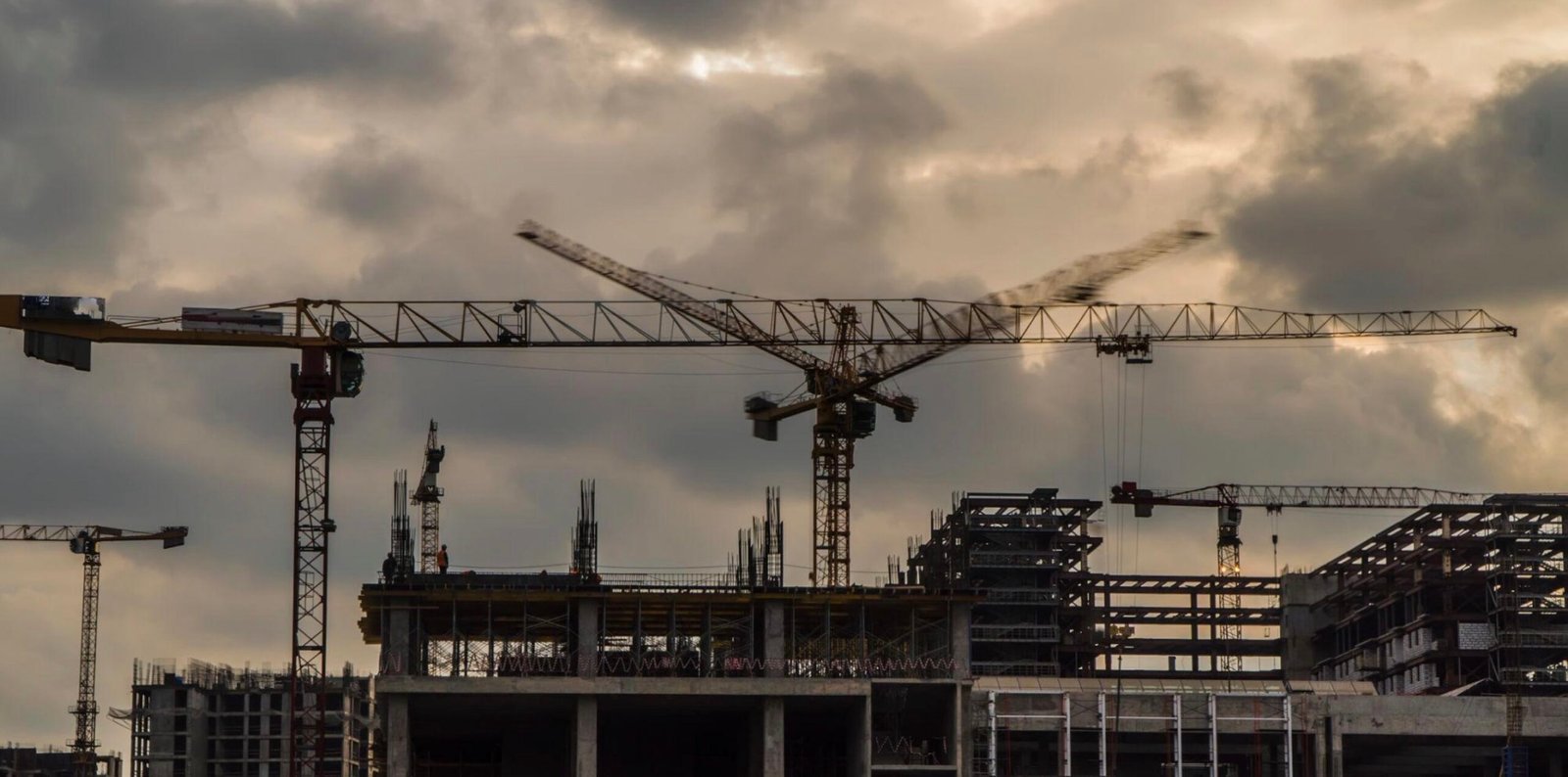 Tower cranes at sunset construction site