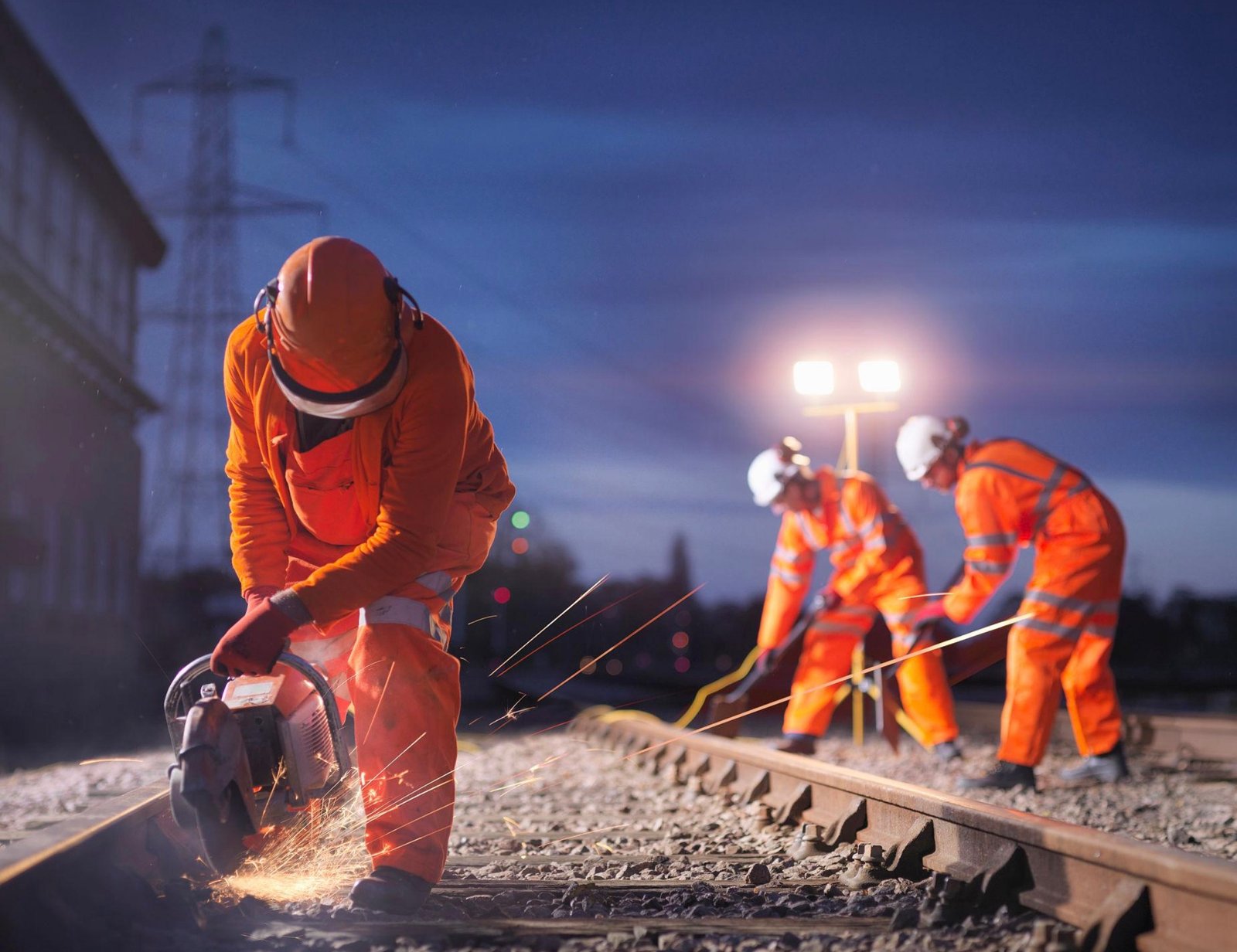 Workers in orange gear on tracks