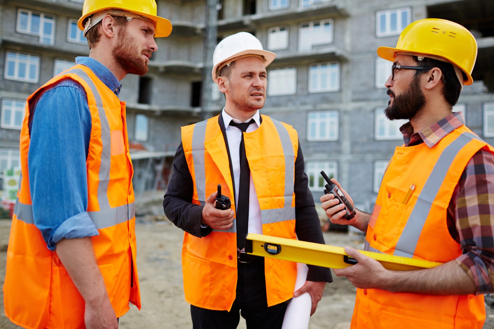 Young builders with walkie-talkies interacting at construction site