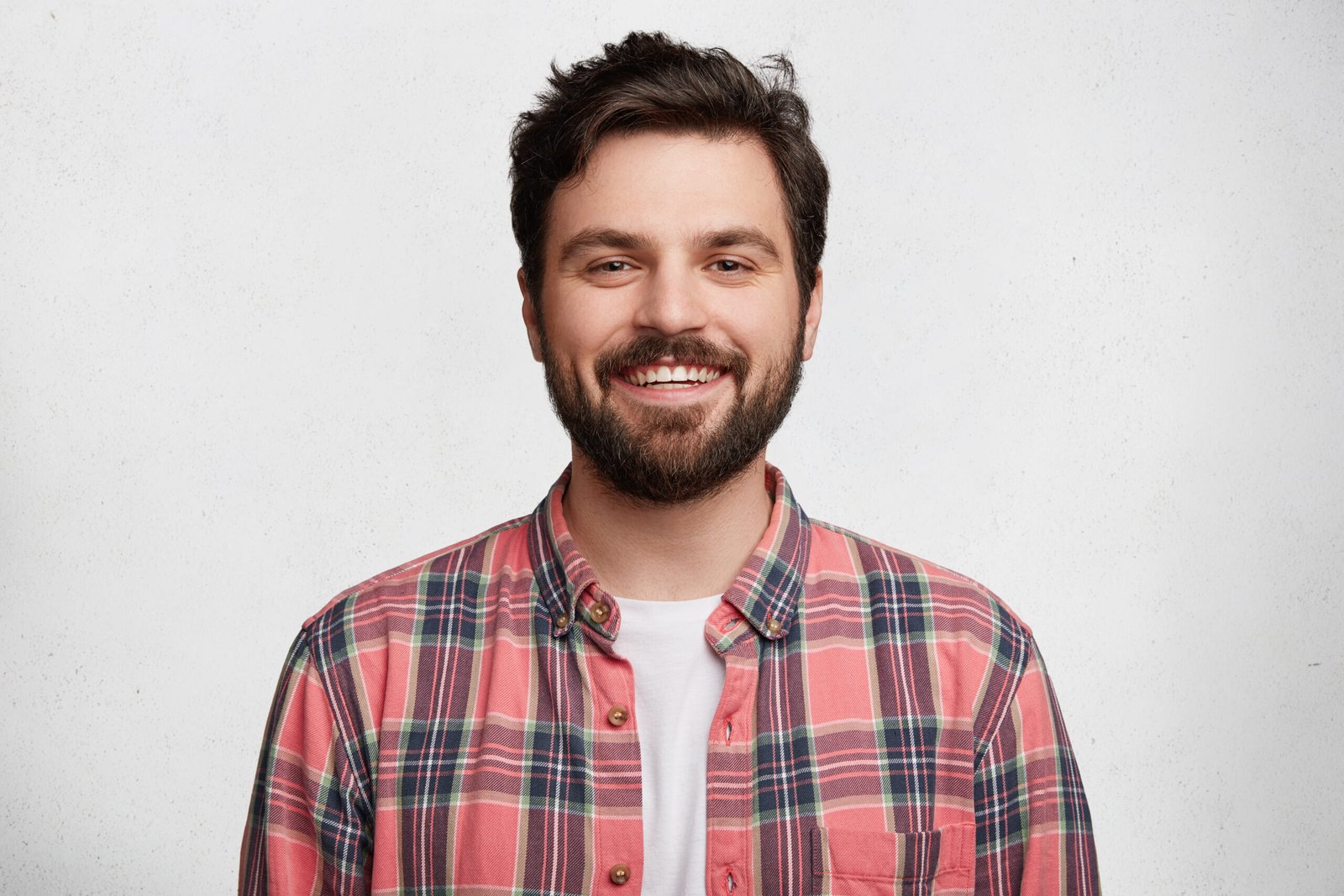 Smiling man wearing pink plaid shirt